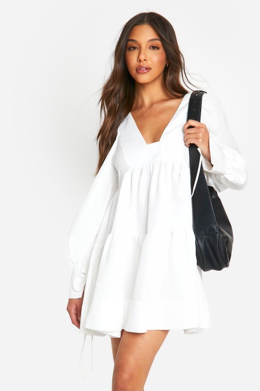 Tiered smock design for a flattering silhouette
        Voluminous puff sleeves add a romantic touch
        V-neckline enhances the feminine appeal
        Relaxed fit for ultimate comfort and ease of movement
        Versatile length suitable for various casual occasions
    
    Embrace effortless style with this charming tiered smock dress from Boohoo. Perfect for the fashion-forward woman who values both comfort and trend-setting looks, this dress radiates a carefree vibe ideal for various casual settings. The tiered design creates a flattering silhouette that skims the body, while the puff sleeves add a touch of whimsy and romance. Style it with chunky boots for an edgy contrast, or pair with your favourite trainers for a laid-back ensemble. Whether you're heading to a family gathering, brunch with friends, or a casual day out, this dress offers the versatility you need. Accessorise with a crossbody bag and delicate jewellery to complete your look. Easy to wear and effortlessly chic, this dress is a must-have addition to your wardrobe, embodying Boohoo's commitment to accessible, on-trend fashion for the young, social butterfly.