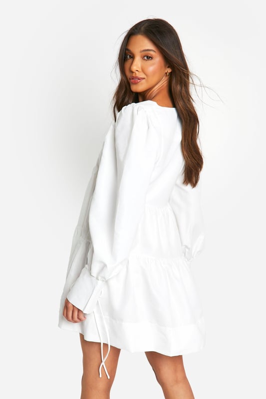 Tiered smock design for a flattering silhouette
        Voluminous puff sleeves add a romantic touch
        V-neckline enhances the feminine appeal
        Relaxed fit for ultimate comfort and ease of movement
        Versatile length suitable for various casual occasions
    
    Embrace effortless style with this charming tiered smock dress from Boohoo. Perfect for the fashion-forward woman who values both comfort and trend-setting looks, this dress radiates a carefree vibe ideal for various casual settings. The tiered design creates a flattering silhouette that skims the body, while the puff sleeves add a touch of whimsy and romance. Style it with chunky boots for an edgy contrast, or pair with your favourite trainers for a laid-back ensemble. Whether you're heading to a family gathering, brunch with friends, or a casual day out, this dress offers the versatility you need. Accessorise with a crossbody bag and delicate jewellery to complete your look. Easy to wear and effortlessly chic, this dress is a must-have addition to your wardrobe, embodying Boohoo's commitment to accessible, on-trend fashion for the young, social butterfly.