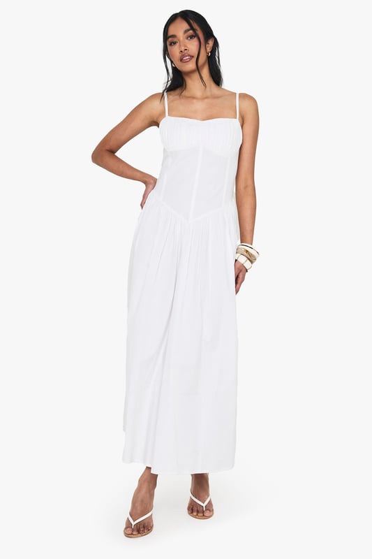 Crafted from breathable cotton poplin for all-day comfort
        Flattering milkmaid design with structured bodice and flowing maxi skirt
        Elegant sweetheart neckline to showcase your dcolletage
        Delicate adjustable shoulder straps for the perfect fit
        Ankle-grazing maxi length ideal for warm-weather styling
    
    This cotton milkmaid maxi dress captures effortless summer style with its classic silhouette and breezy appeal. The structured bodice creates a flattering shape while the sweetheart neckline adds a touch of feminine charm. Perfect for casual daytime events, style with flat sandals and a mini handbag as shown for a relaxed brunch with friends or family gatherings. For cooler evenings, layer with a lightweight denim jacket and accessorise with bangles for added interest. The versatile design transitions beautifully from garden parties to beachside strolls, making it a wardrobe essential for the warmer months. The cotton fabric ensures breathability whilst the maxi length offers a graceful movement that complements any casual occasion.