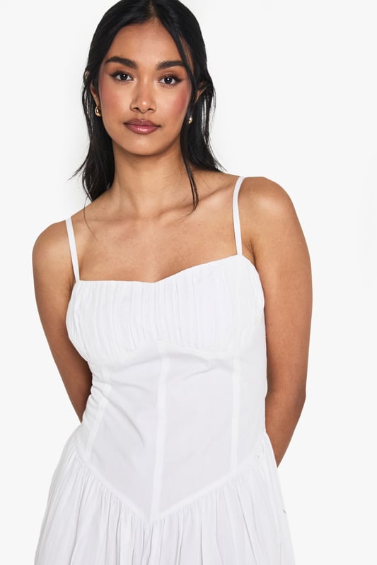 Crafted from breathable cotton poplin for all-day comfort
        Flattering milkmaid design with structured bodice and flowing maxi skirt
        Elegant sweetheart neckline to showcase your dcolletage
        Delicate adjustable shoulder straps for the perfect fit
        Ankle-grazing maxi length ideal for warm-weather styling
    
    This cotton milkmaid maxi dress captures effortless summer style with its classic silhouette and breezy appeal. The structured bodice creates a flattering shape while the sweetheart neckline adds a touch of feminine charm. Perfect for casual daytime events, style with flat sandals and a mini handbag as shown for a relaxed brunch with friends or family gatherings. For cooler evenings, layer with a lightweight denim jacket and accessorise with bangles for added interest. The versatile design transitions beautifully from garden parties to beachside strolls, making it a wardrobe essential for the warmer months. The cotton fabric ensures breathability whilst the maxi length offers a graceful movement that complements any casual occasion.