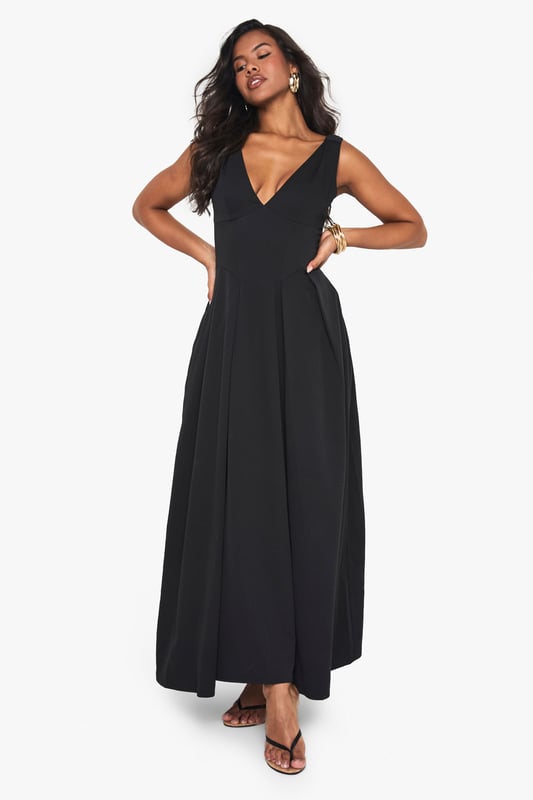 Textured crepe fabric adds subtle dimension and visual interest to this skater-style maxi dress
        Flattering plunge neckline creates an elegant focal point for evening occasions
        Sleeveless design offers comfort for dancing the night away
        Full skater skirt with structured pleating creates a dramatic silhouette
        Floor-length maxi cut makes a bold statement for special nights out
    
    Make an entrance in this striking skater maxi dress from Boohoo. The textured crepe fabric drapes beautifully whilst maintaining structure, creating a flattering silhouette that moves gracefully as you walk. The plunge neckline adds a touch of allure without overwhelming, perfect for evening cocktails or club nights. Style with strappy heels and statement jewellery as seen on our model for maximum impact, or dress down with a cropped jacket and chunky heels for drinks with friends. The versatile design transitions effortlessly from bar to dancefloor, making it an essential addition to your going-out wardrobe. For cooler evenings, layer with a fitted blazer and clutch bag to maintain the dress's elegant lines whilst adding practicality.