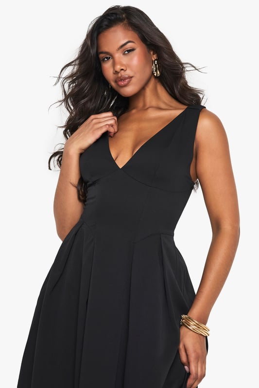 Textured crepe fabric adds subtle dimension and visual interest to this skater-style maxi dress
        Flattering plunge neckline creates an elegant focal point for evening occasions
        Sleeveless design offers comfort for dancing the night away
        Full skater skirt with structured pleating creates a dramatic silhouette
        Floor-length maxi cut makes a bold statement for special nights out
    
    Make an entrance in this striking skater maxi dress from Boohoo. The textured crepe fabric drapes beautifully whilst maintaining structure, creating a flattering silhouette that moves gracefully as you walk. The plunge neckline adds a touch of allure without overwhelming, perfect for evening cocktails or club nights. Style with strappy heels and statement jewellery as seen on our model for maximum impact, or dress down with a cropped jacket and chunky heels for drinks with friends. The versatile design transitions effortlessly from bar to dancefloor, making it an essential addition to your going-out wardrobe. For cooler evenings, layer with a fitted blazer and clutch bag to maintain the dress's elegant lines whilst adding practicality.