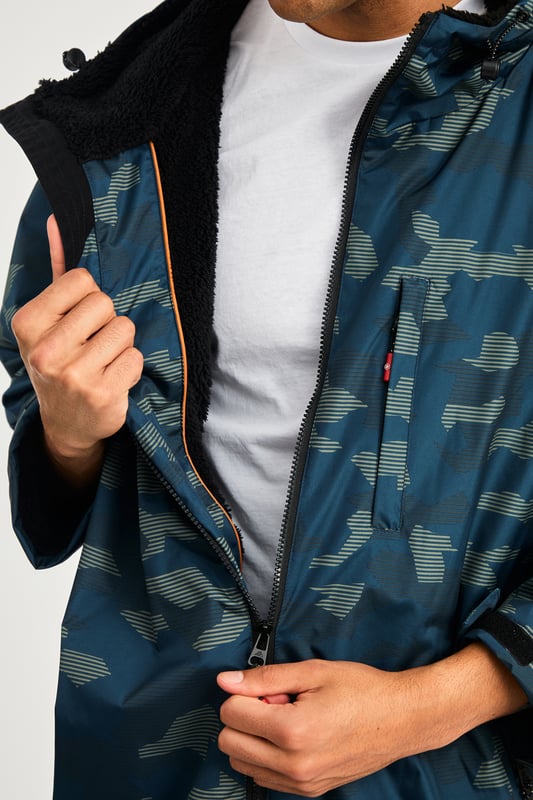 The Northern Expo Dryrobe is a premium mid-length changing robe designed for warmth and comfort. Featuring a luxurious sherpa fleece lining, it provides superior insulation after cold water exposure. With a water-resistant outer shell, three spacious pockets, and a bold logo on the back, it’s perfect for outdoor adventures and recovery.