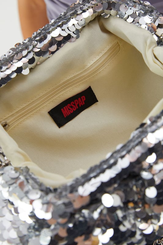 Eye-catching all-over sequin design that catches the light as you move
        Slouchy, soft-structured silhouette for effortless styling
        Secure zip closure to keep your essentials safe
        Chain strap detail for versatile carrying options
        Compact yet spacious enough for night-out essentials
    
    Make a statement with this dazzling Slouchy Sequin Clutch Bag from MissPap. The perfect companion for your night-out adventures, this bag combines practicality with head-turning style. Pair with a sleek bodycon dress or an off-shoulder ensemble for maximum impact at the club. The slouchy design offers a relaxed yet glamorous aesthetic that works brilliantly when you're hitting the town with friends. Versatile enough to complement both minimalist and bold outfits, this clutch transitions seamlessly from pre-drinks to dancefloor. The chain detail allows you to carry it as a shoulder bag when you need your hands free for drinks, while the secure zip closure ensures your phone, cards and lipstick stay safely tucked away as you dance the night away. This bag doesn't just hold your essentials-it becomes an integral part of your going-out look.