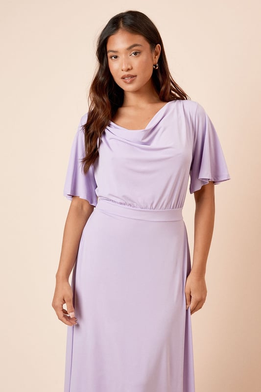 Elegant cowl neckline creates a soft, draped effect at the front
        Flutter sleeves add a feminine touch and gentle movement
        Flattering midi length falls elegantly below the knee
        Tie-back detail creates a customised fit and adds visual interest
        Defined waistline creates a figure-enhancing silhouette
    
    This Dorothy Perkins midi dress combines comfort with sophistication through its graceful cowl neckline and flowing silhouette. The delicate flutter sleeves provide just the right amount of coverage whilst maintaining a light, airy feel. The tie-back detail allows for a personalised fit that accentuates your waistline beautifully. Style with simple strappy sandals and minimal jewellery for casual brunches with the girls, or dress it up with block-heeled ankle boots and a structured crossbody bag for family gatherings. The versatile design makes it perfect for baby showers or afternoon tea, where you can pair it with a lightweight cardigan and ballet flats for a polished yet comfortable ensemble. This dress transitions effortlessly from daytime casual to evening drinks with a simple change of accessories.
