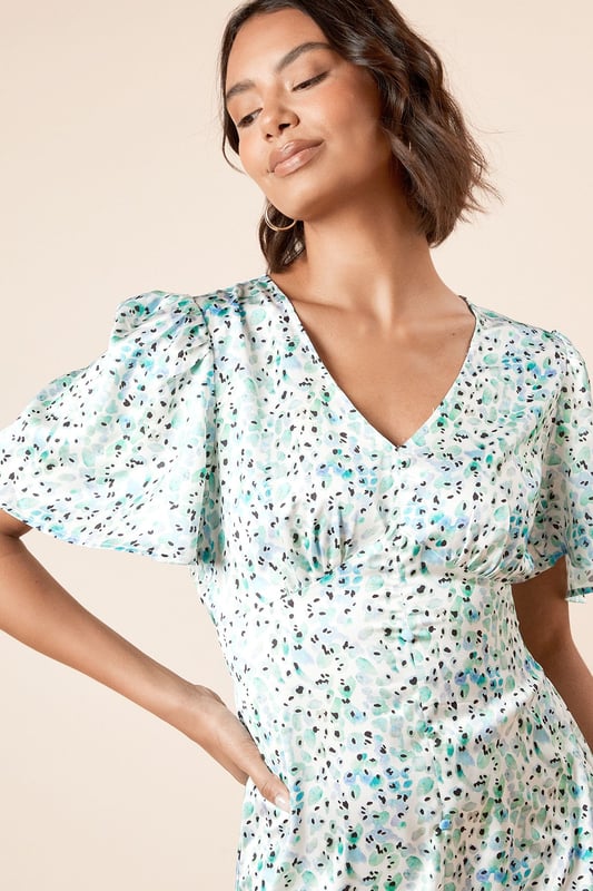 Elegant V-neckline complemented by feminine angel sleeves for a soft, fluttery silhouette
        Midi length design offering sophisticated coverage whilst maintaining a contemporary feel
        Delicate all-over print that adds visual interest to this versatile piece
        Flattering cinched waist detail that creates a beautifully defined silhouette
        Lightweight woven fabric ensuring comfort and ease of movement throughout the day
    
    This charming midi dress from Dorothy Perkins strikes the perfect balance between casual comfort and refined style. The graceful angel sleeves create a soft, feminine frame whilst the V-neckline adds a touch of subtle allure. The cinched waist design gently defines your silhouette, flowing into an elegant midi length that's both practical and stylish. Perfect for casual gatherings, this dress pairs beautifully with flat sandals and a woven tote for weekend brunches with friends. For baby showers or family celebrations, style with block-heeled sandals and delicate jewellery for a polished finish. The versatile design transitions effortlessly from daytime casual to evening drinks - simply swap your flats for ankle boots and add a cropped denim jacket as temperatures cool. Machine washable for easy care, this dress promises to become a cherished staple in your wardrobe.