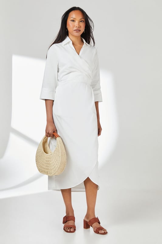 Elegant wrap design with asymmetric hemline for a contemporary silhouette
        Crisp collared neckline adds a refined touch to this versatile piece
        Three-quarter length sleeves offer practical coverage for transitional weather
        Cinched waist detail creates a flattering, feminine shape
        Cotton fabric provides breathable comfort for all-day wear
    
    This Principles wrap skirt collared shirt dress combines timeless sophistication with modern styling. The wrap design gracefully drapes across the body, creating an effortlessly chic look that works beautifully for various daytime occasions. Style with strappy sandals as seen on our model for casual weekend brunches, or pair with white trainers and a denim jacket for shopping trips with friends. The collared detail adds structure while the midi length offers versatility for family gatherings or informal work settings. For cooler days, layer with a lightweight cardigan and ankle boots. The cotton construction ensures comfort throughout the day, making this dress a practical yet stylish addition to your wardrobe that transitions seamlessly from casual coffee dates to relaxed dinner parties with minimal accessorising.