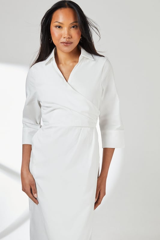 Elegant wrap design with asymmetric hemline for a contemporary silhouette
        Crisp collared neckline adds a refined touch to this versatile piece
        Three-quarter length sleeves offer practical coverage for transitional weather
        Cinched waist detail creates a flattering, feminine shape
        Cotton fabric provides breathable comfort for all-day wear
    
    This Principles wrap skirt collared shirt dress combines timeless sophistication with modern styling. The wrap design gracefully drapes across the body, creating an effortlessly chic look that works beautifully for various daytime occasions. Style with strappy sandals as seen on our model for casual weekend brunches, or pair with white trainers and a denim jacket for shopping trips with friends. The collared detail adds structure while the midi length offers versatility for family gatherings or informal work settings. For cooler days, layer with a lightweight cardigan and ankle boots. The cotton construction ensures comfort throughout the day, making this dress a practical yet stylish addition to your wardrobe that transitions seamlessly from casual coffee dates to relaxed dinner parties with minimal accessorising.