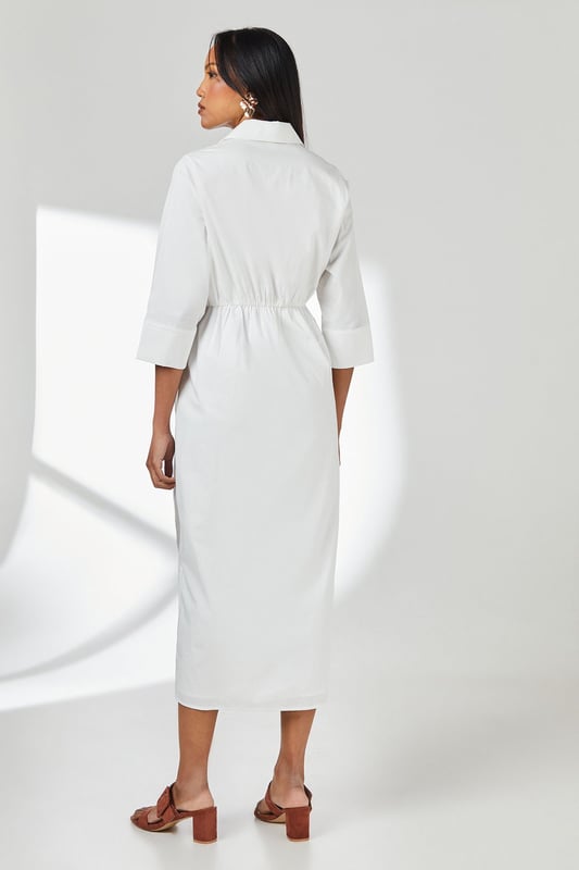 Elegant wrap design with asymmetric hemline for a contemporary silhouette
        Crisp collared neckline adds a refined touch to this versatile piece
        Three-quarter length sleeves offer practical coverage for transitional weather
        Cinched waist detail creates a flattering, feminine shape
        Cotton fabric provides breathable comfort for all-day wear
    
    This Principles wrap skirt collared shirt dress combines timeless sophistication with modern styling. The wrap design gracefully drapes across the body, creating an effortlessly chic look that works beautifully for various daytime occasions. Style with strappy sandals as seen on our model for casual weekend brunches, or pair with white trainers and a denim jacket for shopping trips with friends. The collared detail adds structure while the midi length offers versatility for family gatherings or informal work settings. For cooler days, layer with a lightweight cardigan and ankle boots. The cotton construction ensures comfort throughout the day, making this dress a practical yet stylish addition to your wardrobe that transitions seamlessly from casual coffee dates to relaxed dinner parties with minimal accessorising.