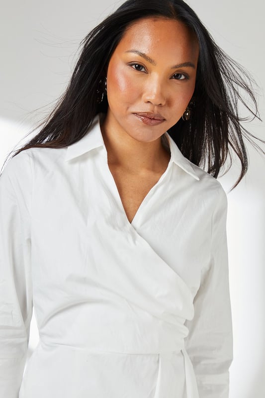 Elegant wrap design with asymmetric hemline for a contemporary silhouette
        Crisp collared neckline adds a refined touch to this versatile piece
        Three-quarter length sleeves offer practical coverage for transitional weather
        Cinched waist detail creates a flattering, feminine shape
        Cotton fabric provides breathable comfort for all-day wear
    
    This Principles wrap skirt collared shirt dress combines timeless sophistication with modern styling. The wrap design gracefully drapes across the body, creating an effortlessly chic look that works beautifully for various daytime occasions. Style with strappy sandals as seen on our model for casual weekend brunches, or pair with white trainers and a denim jacket for shopping trips with friends. The collared detail adds structure while the midi length offers versatility for family gatherings or informal work settings. For cooler days, layer with a lightweight cardigan and ankle boots. The cotton construction ensures comfort throughout the day, making this dress a practical yet stylish addition to your wardrobe that transitions seamlessly from casual coffee dates to relaxed dinner parties with minimal accessorising.