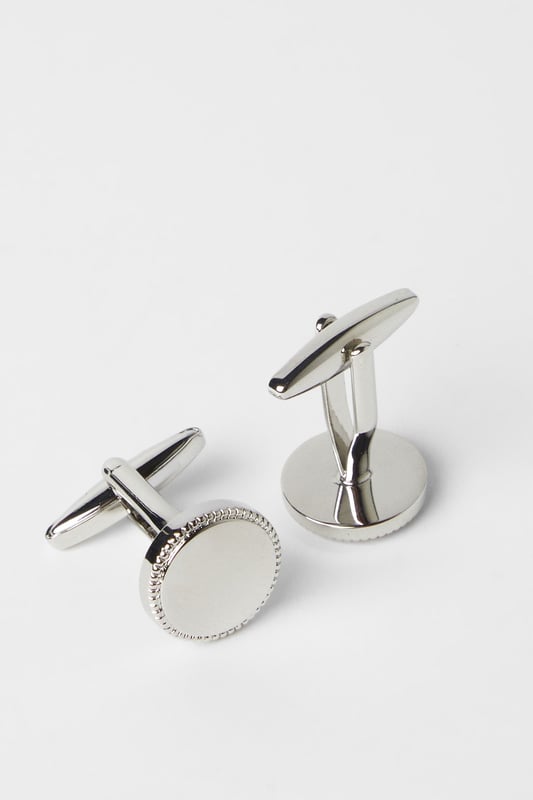 Circular design with textured silver detailing around the edge
        Smooth central face for a refined finish
        Secure T-bar fastening for easy application
        Classic metallic finish that complements any formal shirt
        Subtle yet distinctive accessory to complete your smart ensemble
    
    These sophisticated circle cufflinks add a touch of distinction to any formal outfit. The elegant silver detailing creates a subtle texture that catches the light without being overstated. Perfect for completing your suit for important meetings, weddings or evening events where attention to detail matters. Pair with a crisp white or light blue shirt to showcase the metallic finish, or match with a darker shirt for a striking contrast. These versatile accessories work brilliantly with both French cuff and double cuff shirts, allowing you to customise your look for various occasions. A staple for the modern gentleman who appreciates classic styling with contemporary appeal - these cufflinks strike the perfect balance between traditional formality and understated style that Burton is known for.