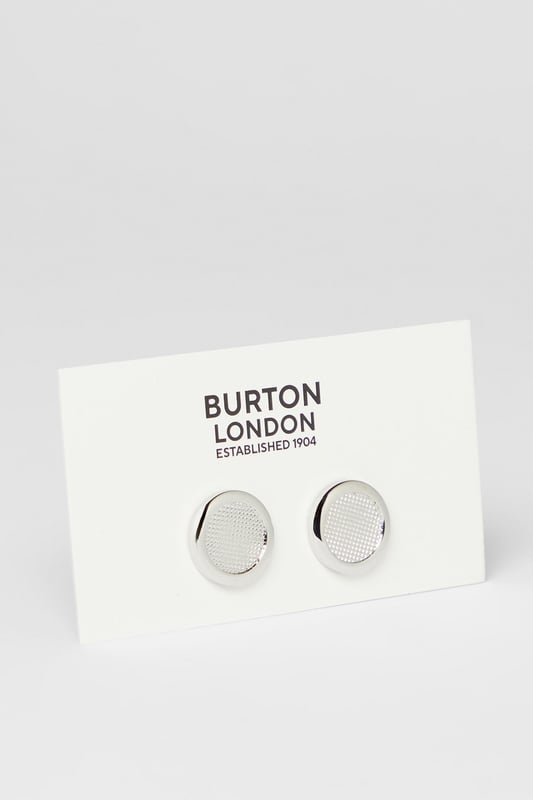 Elegant round design with textured detailing for a sophisticated finish
        Secure toggle fastening ensures cufflinks stay in place throughout the day
        Polished silver-tone metal creates a versatile accessory for formal attire
        Subtle textured pattern adds distinctive character without being overstated
        Classic Burton craftsmanship that complements any formal shirt
    
    These detailed cufflinks offer the perfect finishing touch to your formal ensemble. The textured circular design presents a refined aesthetic that works brilliantly with crisp white shirts or adds character to coloured options. Ideal for important meetings, weddings, or sophisticated evening events, they provide just the right amount of polish without appearing ostentatious. Pair with a tailored Burton suit for a coordinated look, or use them to sharpen up a smart casual outfit when you want to make an impression. The timeless design ensures these cufflinks will remain a staple in your accessories collection, offering versatility across various occasions where you need to present a distinguished appearance. Their understated elegance makes them suitable for everything from job interviews to anniversary dinners.