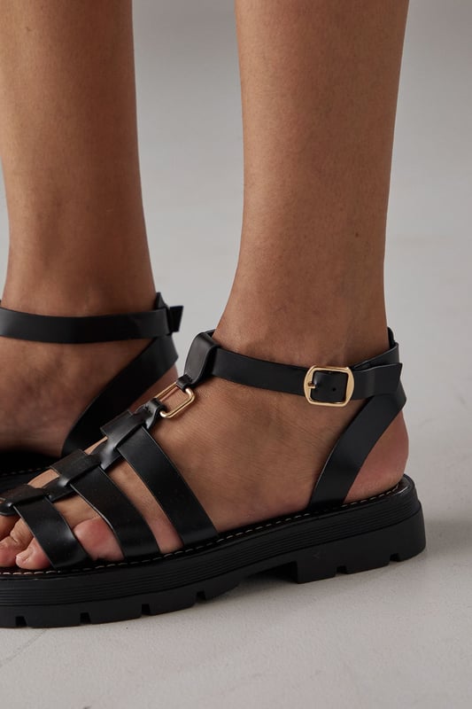 Distinctive T-bar design with multiple strappy details for a contemporary gladiator-inspired look
        Chunky, durable outsole with textured grip providing excellent stability
        Adjustable ankle strap with gold-tone buckle fastening for a secure, customisable fit
        Low heel height between 2.5-4.5cm offering comfortable all-day wear
        Faux leather construction with a smooth finish that complements both casual and smart-casual outfits
    
    These Faith Rosie sandals strike the perfect balance between practicality and style. The chunky silhouette and strappy T-bar design create a modern aesthetic that works beautifully with flowing summer dresses, as shown in the images with the eyelet cotton dress. The low heel provides just enough height whilst maintaining comfort for extended wear, making these ideal for summer garden parties, weekend brunches or holiday sightseeing. The neutral tone allows for versatile styling-pair with cropped trousers and a linen shirt for casual daytime events, or match with a midi skirt and lightweight blouse for family gatherings. The durable outsole ensures these sandals are practical for various terrains, while the adjustable ankle strap offers security and comfort as you move. These Faith sandals will quickly become your go-to footwear for the warmer months.