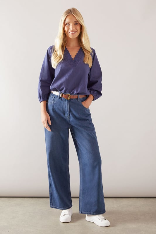 Elegant V-neckline with delicate ruffle trim detailing
        Relaxed overhead design for effortless styling
        Soft cotton fabric ensures all-day comfort
        Versatile three-quarter length balloon sleeves
        Flattering petite fit, perfect for smaller frames
    
    This charming Wallis ruffle overhead shirt combines sophisticated style with everyday comfort. The delicate ruffle trim along the V-neckline adds a feminine touch to this versatile piece, while the relaxed silhouette ensures a flattering fit for various body types. Style it as shown with wide-leg denim and trainers for casual weekend brunches, or tuck it into tailored trousers with ballet flats for family gatherings. The lightweight cotton construction makes it ideal for layering under cardigans during cooler months or wearing alone during warmer days. Perfect for daytime occasions when you want to look polished yet comfortable, this shirt will quickly become a wardrobe staple that transitions seamlessly from shopping trips to casual lunch dates with friends.