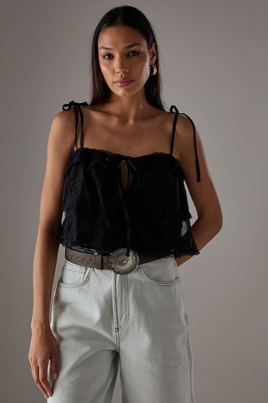 Delicate lace overlay with intricate bohemian-inspired pattern
        Adjustable tie straps for a customised fit
        Cropped length perfect for high-waisted styling
        Tiered design creating a relaxed, floaty silhouette
        Subtle front tie detail adding feminine charm
    
    This Warehouse Bohemian Lace Cami Top brings effortless style to your casual wardrobe. The delicate lace construction creates a light, airy feel while the cropped silhouette pairs beautifully with high-waisted bottoms. Style with light-wash denim shorts and western boots for a festival-ready look, or team with wide-leg trousers and trainers for weekend brunches. The adjustable straps ensure comfort throughout the day, while the tiered design adds movement and dimension. Perfect for summer gatherings, garden parties or holiday evenings, this versatile piece can be dressed down with a denim jacket or styled with statement jewellery for more special occasions. Machine washable for easy care, this top combines practicality with Warehouse's signature confident, feminine aesthetic.