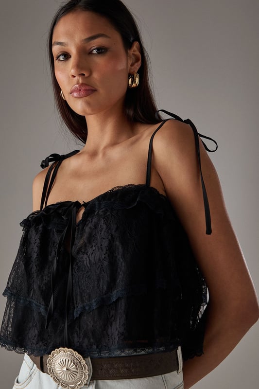 Delicate lace overlay with intricate bohemian-inspired pattern
        Adjustable tie straps for a customised fit
        Cropped length perfect for high-waisted styling
        Tiered design creating a relaxed, floaty silhouette
        Subtle front tie detail adding feminine charm
    
    This Warehouse Bohemian Lace Cami Top brings effortless style to your casual wardrobe. The delicate lace construction creates a light, airy feel while the cropped silhouette pairs beautifully with high-waisted bottoms. Style with light-wash denim shorts and western boots for a festival-ready look, or team with wide-leg trousers and trainers for weekend brunches. The adjustable straps ensure comfort throughout the day, while the tiered design adds movement and dimension. Perfect for summer gatherings, garden parties or holiday evenings, this versatile piece can be dressed down with a denim jacket or styled with statement jewellery for more special occasions. Machine washable for easy care, this top combines practicality with Warehouse's signature confident, feminine aesthetic.
