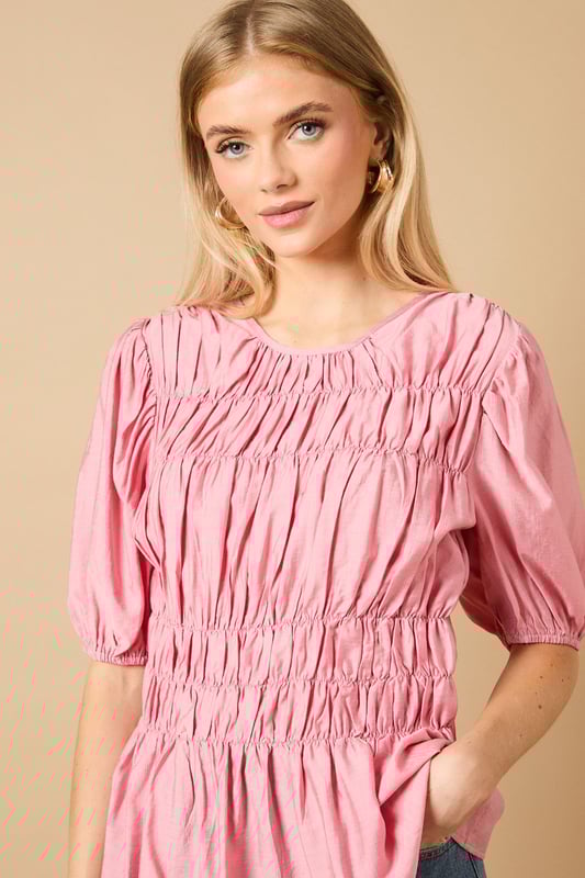 Beautifully textured shirred bodice creates a flattering silhouette
        Charming puff sleeves add a feminine touch to this daywear essential
        Crew neckline offers a classic, versatile finish
        Gathered waist detail creates definition and shape
        Regular fit ensures comfort for all-day wear
    
    This delightful Shirred Bodice Puff Sleeve Top from Oasis brings a touch of romance to your everyday wardrobe. The intricate shirring detail across the bodice creates beautiful texture whilst the puff sleeves add a playful, feminine element that's quintessentially Oasis. Style with relaxed denim jeans and ballet flats for a casual weekend brunch, or pair with tailored trousers and loafers for a smart-casual office look. The versatile crew neckline works beautifully with delicate necklaces or statement earrings. Perfect for family gatherings or casual coffee dates, this top can be layered under a denim jacket when the temperature drops. The gathered waist creates a flattering shape that works wonderfully with both fitted and looser bottoms, making this a truly adaptable piece for your daywear collection.