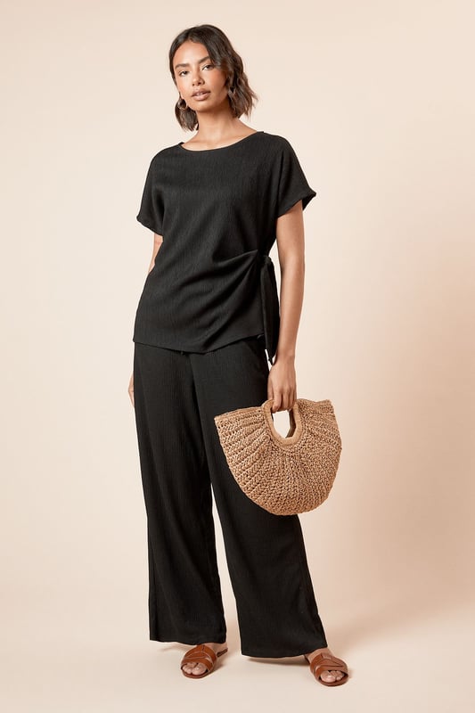Elegant jersey t-shirt featuring a distinctive side knot detail that creates a flattering silhouette
        Classic crew neckline offers versatile styling options for both daytime and evening looks
        Short sleeves with a relaxed fit provide comfortable movement throughout the day
        Soft, textured jersey fabric with slight stretch ensures all-day comfort and shape retention
        Side tie detail adds a contemporary twist to this wardrobe essential
    
    This Dorothy Perkins knot tie side t-shirt effortlessly blends comfort with sophistication. The thoughtful side tie detail creates gentle gathering that flatters your figure whilst adding visual interest to an otherwise simple silhouette. Perfect for casual brunches with friends, pair with wide-leg trousers and sandals as shown for an effortlessly chic daytime ensemble. For family gatherings, style with your favourite denim and ballet flats for a polished yet relaxed look. The versatile crew neckline works beautifully with delicate jewellery for those occasions when you want to appear put-together without trying too hard. The textured jersey fabric drapes beautifully and maintains its shape throughout the day, making this top a reliable choice for your busy lifestyle. A true wardrobe staple that transitions seamlessly from casual coffee dates to baby showers with just a change of accessories.