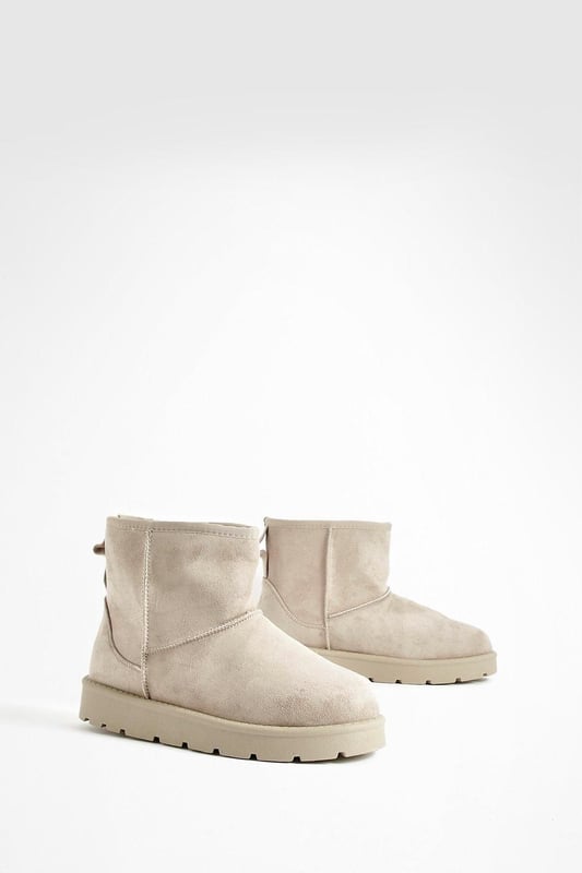 Cosy ankle-height boots for ultimate comfort
        Soft synthetic suede upper for a luxurious feel
        Chunky, durable sole for enhanced grip and stability
        Pull-tab at the back for easy on-and-off
        Versatile design suitable for various casual outfits
    
    Step into comfort and style with these Mini Cosy Boots from Boohoo. Perfect for the fashion-forward woman who values both trendy looks and practicality, these boots are a must-have addition to your casual wardrobe. The ankle-height design offers versatility, making them ideal for pairing with everything from skinny jeans to floaty dresses. The chunky sole not only provides excellent traction but also adds a contemporary edge to your ensemble. Whether you're heading to a laid-back brunch with friends or embarking on a weekend shopping spree, these boots will keep you looking chic and feeling comfortable all day long. For a effortlessly cool look, try teaming them with leggings and an oversized jumper, or dress them up with a midi skirt and cropped jacket for those cooler evenings out.