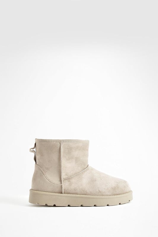 Cosy ankle-height boots for ultimate comfort
        Soft synthetic suede upper for a luxurious feel
        Chunky, durable sole for enhanced grip and stability
        Pull-tab at the back for easy on-and-off
        Versatile design suitable for various casual outfits
    
    Step into comfort and style with these Mini Cosy Boots from Boohoo. Perfect for the fashion-forward woman who values both trendy looks and practicality, these boots are a must-have addition to your casual wardrobe. The ankle-height design offers versatility, making them ideal for pairing with everything from skinny jeans to floaty dresses. The chunky sole not only provides excellent traction but also adds a contemporary edge to your ensemble. Whether you're heading to a laid-back brunch with friends or embarking on a weekend shopping spree, these boots will keep you looking chic and feeling comfortable all day long. For a effortlessly cool look, try teaming them with leggings and an oversized jumper, or dress them up with a midi skirt and cropped jacket for those cooler evenings out.