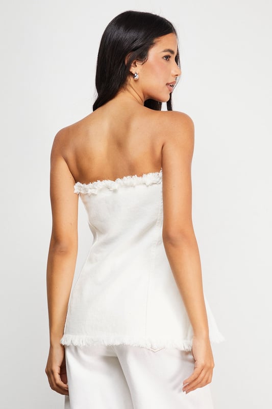 Strapless bandeau design with distinctive frayed edge detailing along the top and bottom hems
        Structured cotton denim fabric provides excellent shape retention and support
        Flattering A-line silhouette that gently flares from the bust to create a feminine profile
        Versatile length that works perfectly as a standalone top or layered piece
        Visible seam detailing adds architectural interest and enhances the contemporary aesthetic
    
    This Warehouse denim bandeau top brings effortless edge to your daywear collection. The raw, frayed edges create a deliberately undone finish that contrasts beautifully with the structured silhouette. Style with the matching frayed denim trousers for a coordinated set that makes a statement, or break it up with your favourite high-waisted jeans for a double denim moment. For casual outings, pair with trainers and oversized gold hoops for an ensemble that transitions seamlessly from weekend brunches to afternoon shopping trips. The cotton fabric offers breathable comfort whilst maintaining its shape throughout the day. This piece embodies Warehouse's confident, feminine aesthetic - perfect for the fashion-forward woman who appreciates contemporary design with a touch of attitude.