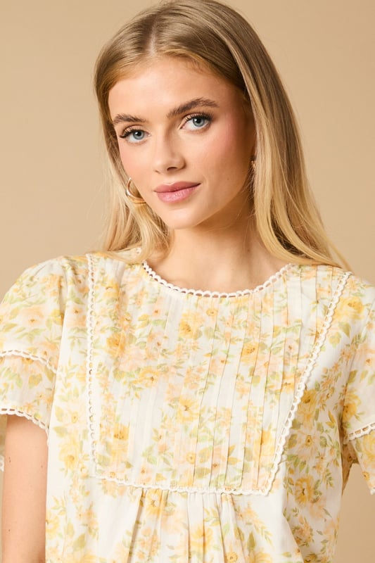 Charming crew neck blouse with delicate frill shoulder detail for a feminine touch
        Elegant pintuck detailing on the front bodice creates subtle texture and visual interest
        Dainty floral print throughout with a soft, romantic aesthetic
        Fluttery short sleeves with pretty trim detailing for added dimension
        Relaxed silhouette with a subtle empire waist for a flattering, comfortable fit
    
    This enchanting Oasis blouse combines classic femininity with contemporary styling. The delicate frill shoulders and pintuck detailing create a wonderfully romantic silhouette that's perfect for everyday wear. Style with relaxed denim jeans and flat sandals for casual weekend brunches, or pair with tailored trousers and ballet flats for a polished office look. The versatile design transitions beautifully from day to evening - simply swap your daytime accessories for statement earrings and a clutch bag for dinner with friends. The blouse's relaxed fit ensures all-day comfort whilst maintaining a put-together appearance, making it an ideal choice for family gatherings or casual meetups. This charming piece captures Oasis's signature feminine aesthetic whilst offering practical versatility for your everyday wardrobe.