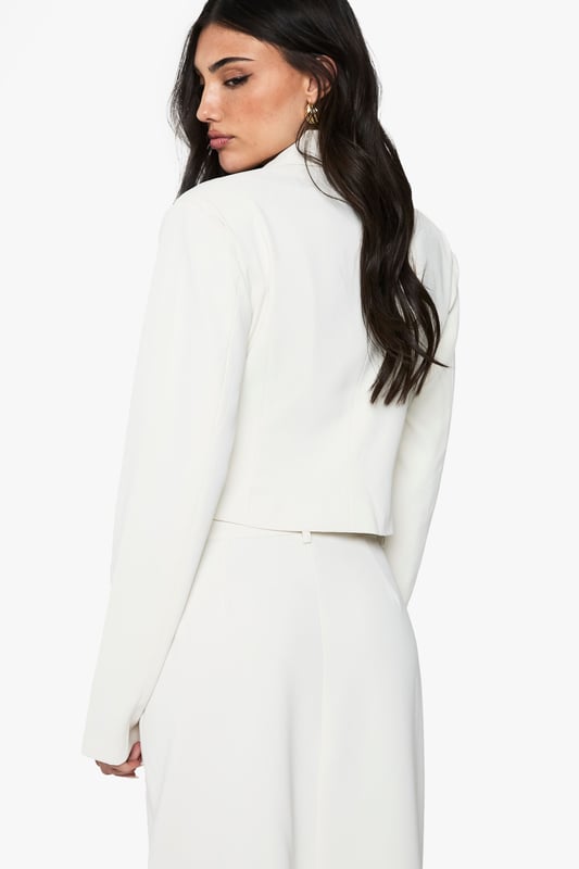 Sophisticated woven blazer featuring elegant ruching detail for added texture and visual interest
        Classic collared neckline with a structured lapel design that creates a polished silhouette
        Cropped length perfect for highlighting high-waisted bottoms
        Functional front pockets that maintain the blazer's clean lines
        Regular fit that offers comfortable movement while maintaining a refined shape
    
    This woven ruched blazer from Boohoo brings contemporary flair to traditional tailoring. The distinctive gathering detail adds texture and dimension to this versatile piece, making it a standout addition to your going-out wardrobe. Style with the matching skirt as seen on our model for a coordinated evening ensemble that commands attention at the club or cocktail bar. For a more relaxed interpretation, pair with high-waisted jeans and statement jewellery when meeting friends for drinks. The structured collar and clean lines create a balanced silhouette that works beautifully for urban nightlife settings. This blazer effortlessly transitions from casual drinks to more upscale venues, offering the fashion-forward versatility that the Boohoo girl craves for her social calendar.