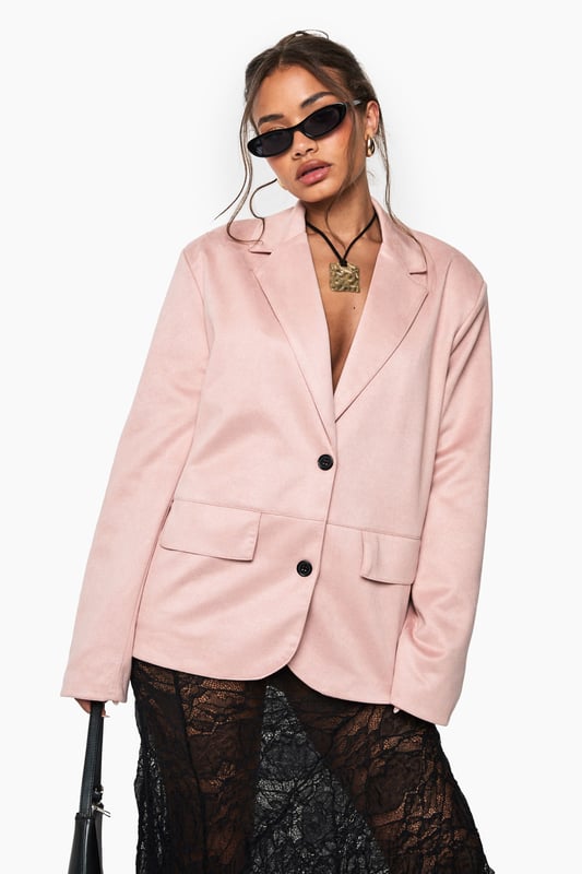 Single-breasted blazer with classic notched lapels for a timeless silhouette
        Soft faux suede texture that adds a tactile dimension to your outfit
        Two functional front pockets perfect for small essentials or styling
        Sleek two-button fastening for versatile styling options
        Regular fit design offering comfortable movement while maintaining structure
    
    This faux suede blazer brings effortless sophistication to your night-out wardrobe. The clean lines and structured shoulders create a flattering frame, whilst the soft-touch fabric adds a contemporary twist to traditional tailoring. Style as seen with a statement lace skirt for a captivating contrast of textures, or pair with slim-fit trousers and heels for drinks with the girls. For cooler evenings, layer over a fitted bodysuit or camisole top. Complete the look with statement jewellery and slim sunglasses for that perfect balance of polish and edge. This versatile piece transitions seamlessly from casual brunches to evening cocktails, making it an essential addition to your collection that works across seasons.