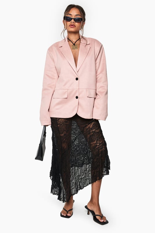 Single-breasted blazer with classic notched lapels for a timeless silhouette
        Soft faux suede texture that adds a tactile dimension to your outfit
        Two functional front pockets perfect for small essentials or styling
        Sleek two-button fastening for versatile styling options
        Regular fit design offering comfortable movement while maintaining structure
    
    This faux suede blazer brings effortless sophistication to your night-out wardrobe. The clean lines and structured shoulders create a flattering frame, whilst the soft-touch fabric adds a contemporary twist to traditional tailoring. Style as seen with a statement lace skirt for a captivating contrast of textures, or pair with slim-fit trousers and heels for drinks with the girls. For cooler evenings, layer over a fitted bodysuit or camisole top. Complete the look with statement jewellery and slim sunglasses for that perfect balance of polish and edge. This versatile piece transitions seamlessly from casual brunches to evening cocktails, making it an essential addition to your collection that works across seasons.
