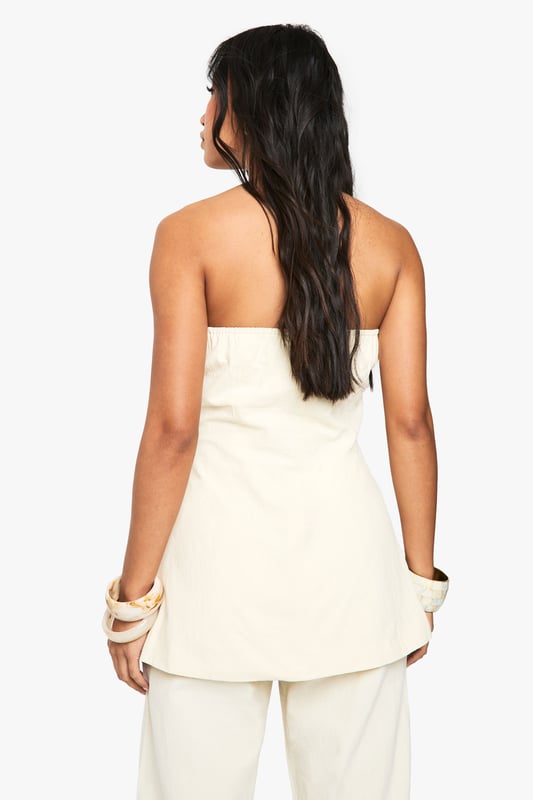Chic bandeau-style vest with button-through front design
        Practical utility pockets at the hip for added functionality
        Structured silhouette that flatters the figure
        Crafted from breathable cotton fabric for all-day comfort
        Versatile regular fit that works beautifully as both a standalone piece or layered item
    
    This sophisticated bandeau vest offers effortless style for the fashion-forward woman. The clean lines and strapless design create a contemporary silhouette that's perfect for warmer days. Style with the matching wide-leg trousers as seen on our model for a coordinated summer ensemble, or pair with your favourite denim for a more casual approach. The cotton fabric ensures breathability whilst maintaining structure, making it ideal for family gatherings or weekend brunches. For evening occasions, layer with a lightweight blazer and accessorise with statement jewellery. This Boohoo piece transitions seamlessly from daytime casual with trainers to evening drinks when styled with strappy sandals, offering remarkable versatility for your wardrobe.