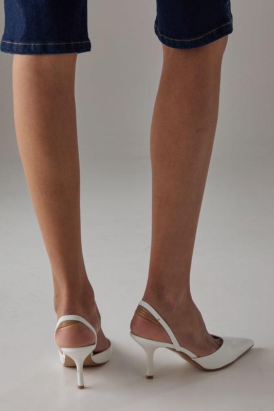 Elegant slingback design with secure ankle strap for comfortable all-day wear
        Pointed toe silhouette creates a flattering, leg-lengthening effect
        Sleek high stiletto heel measuring between 7-9cm adds sophisticated height
        Smooth faux leather finish offers a polished, versatile appearance
        Cushioned footbed provides essential comfort without compromising on style
    
    The Faith Dottie court shoes strike the perfect balance between contemporary design and timeless appeal. The pointed toe and slingback silhouette create a refined shape that complements both casual and smart-casual ensembles. Style these versatile heels with relaxed denim and a floaty blouse for family gatherings, or pair with tailored trousers for an elevated daytime look. The 7-9cm stiletto heel offers just the right amount of height whilst remaining appropriate for everyday occasions. The secure slingback strap ensures these courts stay comfortably in place throughout the day, making them ideal for shopping trips or casual lunches with friends. Their clean lines and sophisticated shape make them a wardrobe essential that will complement numerous outfits in your collection, offering endless styling possibilities for daywear occasions.