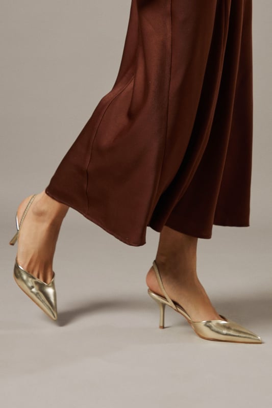 Elegant slingback design with secure ankle strap for comfortable all-day wear
        Pointed toe silhouette creates a flattering, leg-lengthening effect
        Sleek high stiletto heel measuring between 7-9cm adds sophisticated height
        Smooth faux leather finish offers a polished, versatile appearance
        Cushioned footbed provides essential comfort without compromising on style
    
    The Faith Dottie court shoes strike the perfect balance between contemporary design and timeless appeal. The pointed toe and slingback silhouette create a refined shape that complements both casual and smart-casual ensembles. Style these versatile heels with relaxed denim and a floaty blouse for family gatherings, or pair with tailored trousers for an elevated daytime look. The 7-9cm stiletto heel offers just the right amount of height whilst remaining appropriate for everyday occasions. The secure slingback strap ensures these courts stay comfortably in place throughout the day, making them ideal for shopping trips or casual lunches with friends. Their clean lines and sophisticated shape make them a wardrobe essential that will complement numerous outfits in your collection, offering endless styling possibilities for daywear occasions.