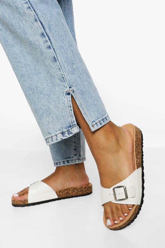 Stylish buckle footbed slider with adjustable strap
        Comfortable cork-effect footbed for enhanced support
        Flat heel between 0 and 2cm for easy all-day wear
        Versatile design suitable for various casual occasions
        Durable synthetic materials for long-lasting use
    
    Step into comfort and style with these trendy buckle footbed sliders from Boohoo. Perfect for the fashion-forward woman who values both aesthetics and practicality, these sandals are a must-have for your casual wardrobe. The adjustable strap ensures a customised fit, while the cork-effect footbed provides a natural, earthy look and superior comfort. Pair them with cropped jeans and a breezy top for a laid-back weekend brunch, or slip them on with a floaty sundress for a relaxed day at the beach. Their versatility makes them ideal for family gatherings, casual outings, or simply lounging at home. The flat heel offers stability and comfort for extended wear, making these sliders your go-to choice for effortless summer style that doesn't compromise on comfort.
