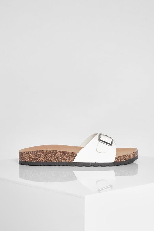 Stylish buckle footbed slider with adjustable strap
        Comfortable cork-effect footbed for enhanced support
        Flat heel between 0 and 2cm for easy all-day wear
        Versatile design suitable for various casual occasions
        Durable synthetic materials for long-lasting use
    
    Step into comfort and style with these trendy buckle footbed sliders from Boohoo. Perfect for the fashion-forward woman who values both aesthetics and practicality, these sandals are a must-have for your casual wardrobe. The adjustable strap ensures a customised fit, while the cork-effect footbed provides a natural, earthy look and superior comfort. Pair them with cropped jeans and a breezy top for a laid-back weekend brunch, or slip them on with a floaty sundress for a relaxed day at the beach. Their versatility makes them ideal for family gatherings, casual outings, or simply lounging at home. The flat heel offers stability and comfort for extended wear, making these sliders your go-to choice for effortless summer style that doesn't compromise on comfort.