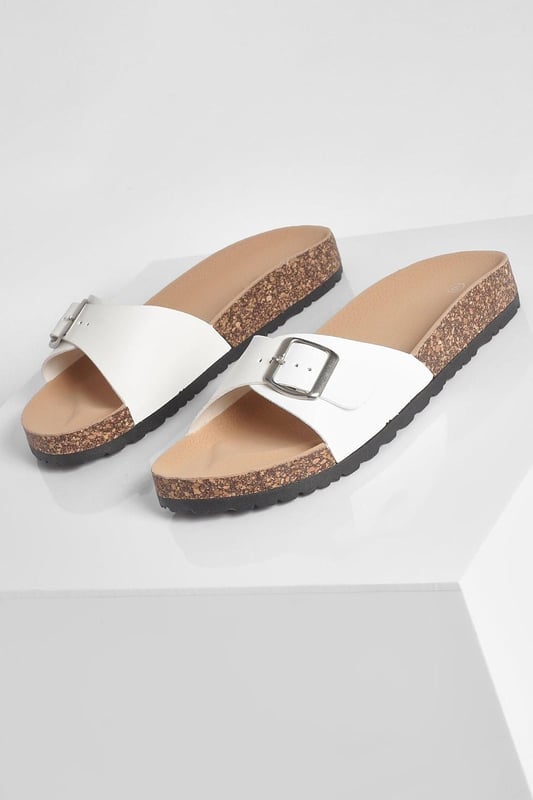 Stylish buckle footbed slider with adjustable strap
        Comfortable cork-effect footbed for enhanced support
        Flat heel between 0 and 2cm for easy all-day wear
        Versatile design suitable for various casual occasions
        Durable synthetic materials for long-lasting use
    
    Step into comfort and style with these trendy buckle footbed sliders from Boohoo. Perfect for the fashion-forward woman who values both aesthetics and practicality, these sandals are a must-have for your casual wardrobe. The adjustable strap ensures a customised fit, while the cork-effect footbed provides a natural, earthy look and superior comfort. Pair them with cropped jeans and a breezy top for a laid-back weekend brunch, or slip them on with a floaty sundress for a relaxed day at the beach. Their versatility makes them ideal for family gatherings, casual outings, or simply lounging at home. The flat heel offers stability and comfort for extended wear, making these sliders your go-to choice for effortless summer style that doesn't compromise on comfort.