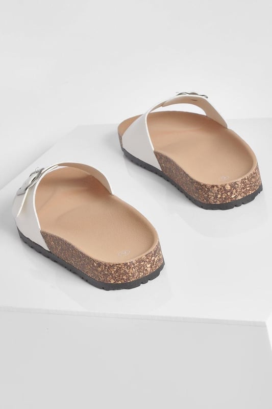 Stylish buckle footbed slider with adjustable strap
        Comfortable cork-effect footbed for enhanced support
        Flat heel between 0 and 2cm for easy all-day wear
        Versatile design suitable for various casual occasions
        Durable synthetic materials for long-lasting use
    
    Step into comfort and style with these trendy buckle footbed sliders from Boohoo. Perfect for the fashion-forward woman who values both aesthetics and practicality, these sandals are a must-have for your casual wardrobe. The adjustable strap ensures a customised fit, while the cork-effect footbed provides a natural, earthy look and superior comfort. Pair them with cropped jeans and a breezy top for a laid-back weekend brunch, or slip them on with a floaty sundress for a relaxed day at the beach. Their versatility makes them ideal for family gatherings, casual outings, or simply lounging at home. The flat heel offers stability and comfort for extended wear, making these sliders your go-to choice for effortless summer style that doesn't compromise on comfort.