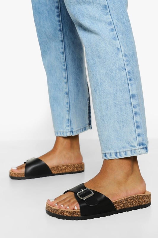 Stylish buckle footbed slider with adjustable strap
        Comfortable cork-effect footbed for enhanced support
        Flat heel between 0 and 2cm for easy all-day wear
        Versatile design suitable for various casual occasions
        Durable synthetic materials for long-lasting use
    
    Step into comfort and style with these trendy buckle footbed sliders from Boohoo. Perfect for the fashion-forward woman who values both aesthetics and practicality, these sandals are a must-have for your casual wardrobe. The adjustable strap ensures a customised fit, while the cork-effect footbed provides a natural, earthy look and superior comfort. Pair them with cropped jeans and a breezy top for a laid-back weekend brunch, or slip them on with a floaty sundress for a relaxed day at the beach. Their versatility makes them ideal for family gatherings, casual outings, or simply lounging at home. The flat heel offers stability and comfort for extended wear, making these sliders your go-to choice for effortless summer style that doesn't compromise on comfort.