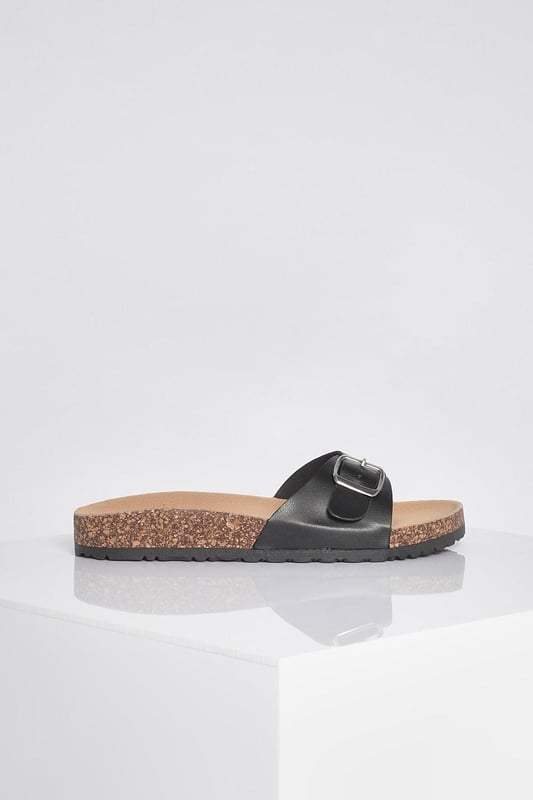 Stylish buckle footbed slider with adjustable strap
        Comfortable cork-effect footbed for enhanced support
        Flat heel between 0 and 2cm for easy all-day wear
        Versatile design suitable for various casual occasions
        Durable synthetic materials for long-lasting use
    
    Step into comfort and style with these trendy buckle footbed sliders from Boohoo. Perfect for the fashion-forward woman who values both aesthetics and practicality, these sandals are a must-have for your casual wardrobe. The adjustable strap ensures a customised fit, while the cork-effect footbed provides a natural, earthy look and superior comfort. Pair them with cropped jeans and a breezy top for a laid-back weekend brunch, or slip them on with a floaty sundress for a relaxed day at the beach. Their versatility makes them ideal for family gatherings, casual outings, or simply lounging at home. The flat heel offers stability and comfort for extended wear, making these sliders your go-to choice for effortless summer style that doesn't compromise on comfort.