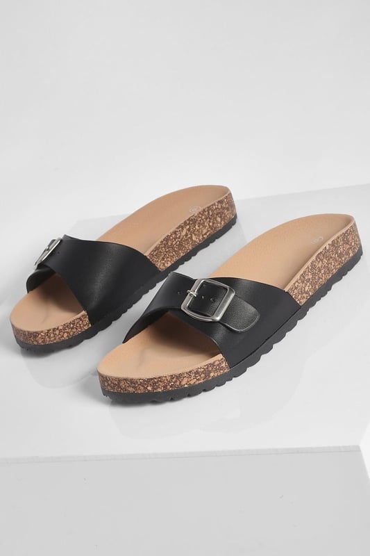 Stylish buckle footbed slider with adjustable strap
        Comfortable cork-effect footbed for enhanced support
        Flat heel between 0 and 2cm for easy all-day wear
        Versatile design suitable for various casual occasions
        Durable synthetic materials for long-lasting use
    
    Step into comfort and style with these trendy buckle footbed sliders from Boohoo. Perfect for the fashion-forward woman who values both aesthetics and practicality, these sandals are a must-have for your casual wardrobe. The adjustable strap ensures a customised fit, while the cork-effect footbed provides a natural, earthy look and superior comfort. Pair them with cropped jeans and a breezy top for a laid-back weekend brunch, or slip them on with a floaty sundress for a relaxed day at the beach. Their versatility makes them ideal for family gatherings, casual outings, or simply lounging at home. The flat heel offers stability and comfort for extended wear, making these sliders your go-to choice for effortless summer style that doesn't compromise on comfort.