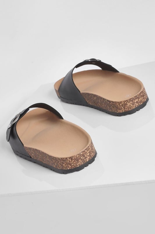 Stylish buckle footbed slider with adjustable strap
        Comfortable cork-effect footbed for enhanced support
        Flat heel between 0 and 2cm for easy all-day wear
        Versatile design suitable for various casual occasions
        Durable synthetic materials for long-lasting use
    
    Step into comfort and style with these trendy buckle footbed sliders from Boohoo. Perfect for the fashion-forward woman who values both aesthetics and practicality, these sandals are a must-have for your casual wardrobe. The adjustable strap ensures a customised fit, while the cork-effect footbed provides a natural, earthy look and superior comfort. Pair them with cropped jeans and a breezy top for a laid-back weekend brunch, or slip them on with a floaty sundress for a relaxed day at the beach. Their versatility makes them ideal for family gatherings, casual outings, or simply lounging at home. The flat heel offers stability and comfort for extended wear, making these sliders your go-to choice for effortless summer style that doesn't compromise on comfort.