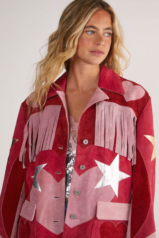Genuine suede jacket featuring dramatic fringe detailing across the shoulders and sleeves
        Statement star pattern design for a bold, eye-catching look
        Button-through front closure with classic collar
        Practical patch pockets at the front
        Relaxed silhouette for comfortable layering
    
    Make a striking entrance in this show-stopping Real Suede Heart Fringe Jacket from Nasty Gal. The dramatic fringe detailing creates movement with every step, whilst the bold star pattern commands attention wherever you go. Perfect for those nights when ordinary simply won't do, this jacket pairs brilliantly with denim shorts and metallic boots as shown, or style with skinny jeans and a simple camisole to let the jacket take centre stage. The genuine suede construction offers a luxurious feel that will develop character over time. Whether you're heading to a gig, meeting friends at a trendy bar, or dancing the night away, this distinctive piece will ensure you stand out from the crowd. The relaxed fit allows for easy layering over both casual and dressier ensembles, making it a versatile addition to your going-out wardrobe.