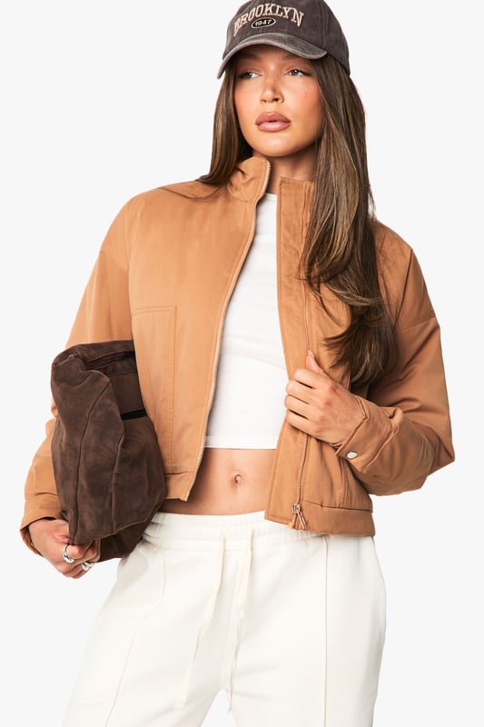 Distinctive funnel collar design for added warmth and contemporary style
        Cropped silhouette perfect for highlighting high-waisted bottoms
        Ribbed cuffs and hem for a snug, comfortable fit
        Front zip fastening for easy wear and versatile styling options
        Practical side pockets for everyday functionality
    
    This bomber jacket combines classic athletic appeal with modern design elements, making it a versatile addition to your casual wardrobe. The distinctive funnel collar adds a contemporary twist while providing extra protection against the elements. Style with wide-leg trousers and a crop top as shown for an effortlessly cool daytime look, or pair with slim-fit jeans and trainers for weekend coffee runs. The cropped length works brilliantly with high-waisted bottoms, creating a balanced silhouette. Perfect for family gatherings, casual brunches or shopping trips with friends, this Boohoo bomber can be layered over hoodies during cooler months or worn with lightweight tops when the temperature rises. Accessorise with a baseball cap and minimal jewellery for an understated finish that maintains the jacket's relaxed yet fashion-forward appeal.