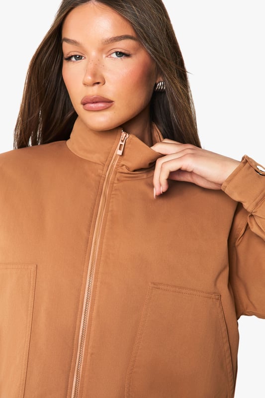 Distinctive funnel collar design for added warmth and contemporary style
        Cropped silhouette perfect for highlighting high-waisted bottoms
        Ribbed cuffs and hem for a snug, comfortable fit
        Front zip fastening for easy wear and versatile styling options
        Practical side pockets for everyday functionality
    
    This bomber jacket combines classic athletic appeal with modern design elements, making it a versatile addition to your casual wardrobe. The distinctive funnel collar adds a contemporary twist while providing extra protection against the elements. Style with wide-leg trousers and a crop top as shown for an effortlessly cool daytime look, or pair with slim-fit jeans and trainers for weekend coffee runs. The cropped length works brilliantly with high-waisted bottoms, creating a balanced silhouette. Perfect for family gatherings, casual brunches or shopping trips with friends, this Boohoo bomber can be layered over hoodies during cooler months or worn with lightweight tops when the temperature rises. Accessorise with a baseball cap and minimal jewellery for an understated finish that maintains the jacket's relaxed yet fashion-forward appeal.