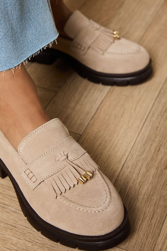 Crafted from soft suede with decorative tassel detailing for a classic finish
        Chunky sole provides excellent grip and all-day comfort
        Flat heel height (under 2cm) ideal for extended wear
        Traditional loafer silhouette with contemporary proportions
        Gold-tone hardware accent adds a subtle touch of sophistication
    
    The Brooke Suede Tassel Loafers from Oasis present the perfect blend of comfort and style for your everyday wardrobe. These versatile flats showcase charming tassel detailing that nods to traditional loafer design whilst maintaining a fresh, feminine appeal. Style them as seen with relaxed denim and a flowing blouse for casual weekend brunches, or pair with tailored trousers and a crisp shirt for a smart-casual office look. The chunky, durable sole offers practical wearability whilst the neutral tone ensures these loafers will complement virtually any outfit in your collection. Perfect for city exploring, shopping trips or casual gatherings where comfort cannot be compromised, these loafers will quickly become your go-to footwear choice for occasions that require both style and practicality.