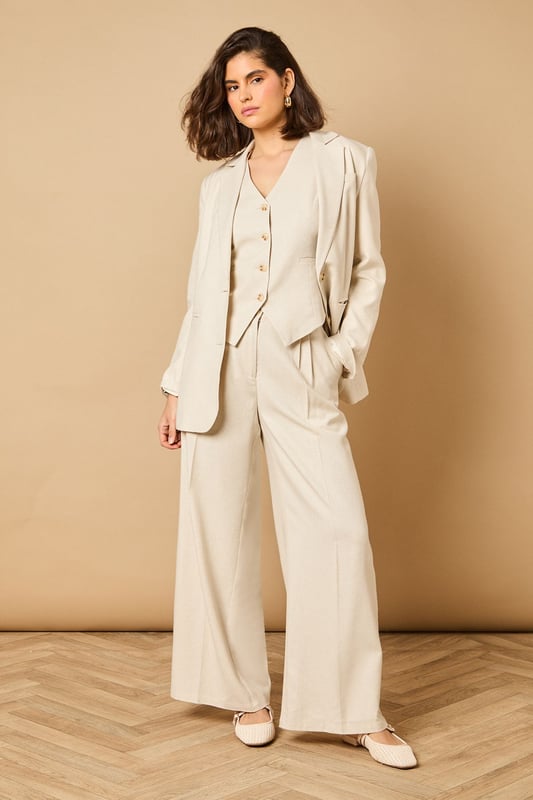Tailored wide leg design with elegant front pleats for a flattering silhouette
        High-rise waistband with button fastening for a secure and comfortable fit
        Practical side pockets perfect for everyday essentials
        Flowing wide leg cut creates a graceful drape when walking
        Versatile woven fabric suitable for both formal occasions and smart-casual styling
    
    These sophisticated wide leg trousers from Oasis present the perfect balance of comfort and elegance. The tailored design features a flattering high waist that creates a sleek silhouette, whilst the generous wide leg cut offers a contemporary twist on classic formal wear. Style with the coordinating waistcoat for a chic two-piece ensemble perfect for summer weddings and race day events. For more relaxed occasions, pair with a simple silk camisole and metallic sandals as shown. The clean lines and structured fabric make these trousers an excellent choice for important meetings or graduation ceremonies, whilst their lightweight feel ensures you'll remain comfortable throughout the day. Add statement jewellery and a clutch bag to transform them into an evening-ready outfit that radiates refined femininity.