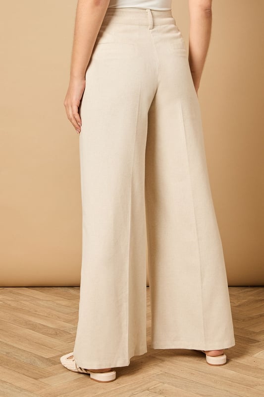 Tailored wide leg design with elegant front pleats for a flattering silhouette
        High-rise waistband with button fastening for a secure and comfortable fit
        Practical side pockets perfect for everyday essentials
        Flowing wide leg cut creates a graceful drape when walking
        Versatile woven fabric suitable for both formal occasions and smart-casual styling
    
    These sophisticated wide leg trousers from Oasis present the perfect balance of comfort and elegance. The tailored design features a flattering high waist that creates a sleek silhouette, whilst the generous wide leg cut offers a contemporary twist on classic formal wear. Style with the coordinating waistcoat for a chic two-piece ensemble perfect for summer weddings and race day events. For more relaxed occasions, pair with a simple silk camisole and metallic sandals as shown. The clean lines and structured fabric make these trousers an excellent choice for important meetings or graduation ceremonies, whilst their lightweight feel ensures you'll remain comfortable throughout the day. Add statement jewellery and a clutch bag to transform them into an evening-ready outfit that radiates refined femininity.