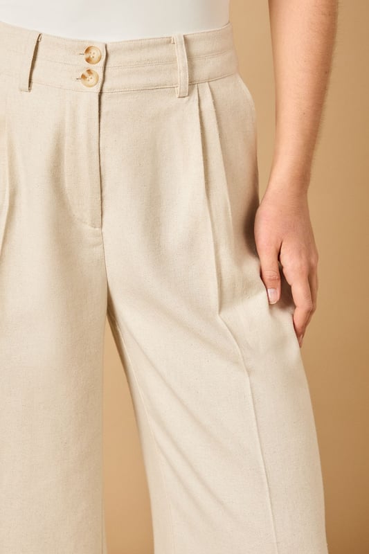Tailored wide leg design with elegant front pleats for a flattering silhouette
        High-rise waistband with button fastening for a secure and comfortable fit
        Practical side pockets perfect for everyday essentials
        Flowing wide leg cut creates a graceful drape when walking
        Versatile woven fabric suitable for both formal occasions and smart-casual styling
    
    These sophisticated wide leg trousers from Oasis present the perfect balance of comfort and elegance. The tailored design features a flattering high waist that creates a sleek silhouette, whilst the generous wide leg cut offers a contemporary twist on classic formal wear. Style with the coordinating waistcoat for a chic two-piece ensemble perfect for summer weddings and race day events. For more relaxed occasions, pair with a simple silk camisole and metallic sandals as shown. The clean lines and structured fabric make these trousers an excellent choice for important meetings or graduation ceremonies, whilst their lightweight feel ensures you'll remain comfortable throughout the day. Add statement jewellery and a clutch bag to transform them into an evening-ready outfit that radiates refined femininity.