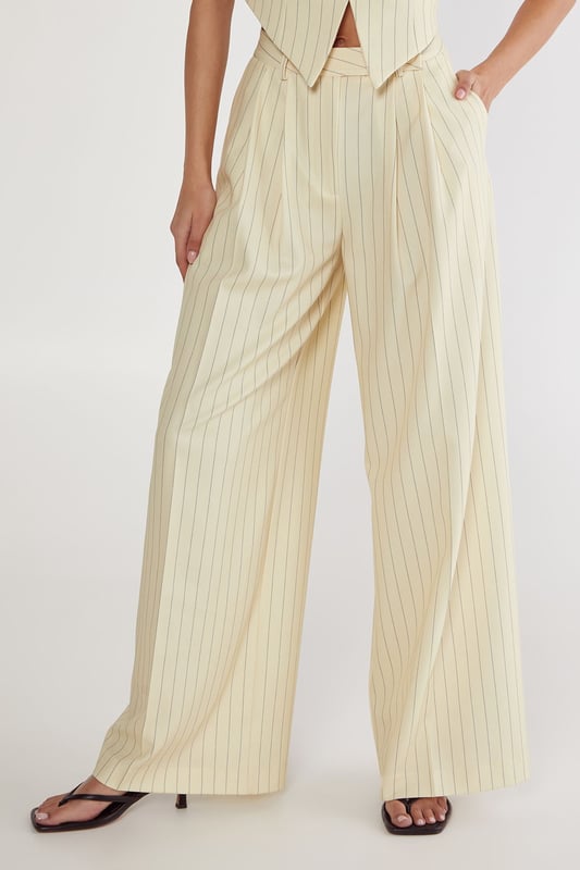 Tailored wide-leg trousers with classic pinstripe pattern
        High-waisted design for a flattering silhouette
        Practical side pockets for everyday essentials
        Wide-leg cut offering comfortable movement
        Versatile design suitable for both professional and casual settings
    
    These Nasty Gal Butter Pinstripe Tailored Trousers bring sophisticated workwear to new heights. The high-waisted design creates a lengthening effect whilst the wide-leg silhouette offers both comfort and contemporary style. Pair with the matching crop top as shown for a coordinated two-piece ensemble that commands attention in the office, or style with a crisp white shirt and blazer for more formal workplace settings. For after-hours events, swap office footwear for strappy heels and add statement jewellery. The versatile pinstripe pattern honours traditional tailoring whilst the modern cut ensures these trousers transition seamlessly from boardroom presentations to evening drinks. The side pockets add practicality to this stylish piece, making these trousers an essential addition to your professional wardrobe.