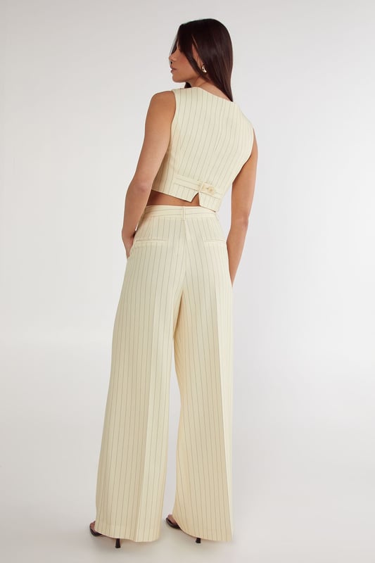 Tailored wide-leg trousers with classic pinstripe pattern
        High-waisted design for a flattering silhouette
        Practical side pockets for everyday essentials
        Wide-leg cut offering comfortable movement
        Versatile design suitable for both professional and casual settings
    
    These Nasty Gal Butter Pinstripe Tailored Trousers bring sophisticated workwear to new heights. The high-waisted design creates a lengthening effect whilst the wide-leg silhouette offers both comfort and contemporary style. Pair with the matching crop top as shown for a coordinated two-piece ensemble that commands attention in the office, or style with a crisp white shirt and blazer for more formal workplace settings. For after-hours events, swap office footwear for strappy heels and add statement jewellery. The versatile pinstripe pattern honours traditional tailoring whilst the modern cut ensures these trousers transition seamlessly from boardroom presentations to evening drinks. The side pockets add practicality to this stylish piece, making these trousers an essential addition to your professional wardrobe.