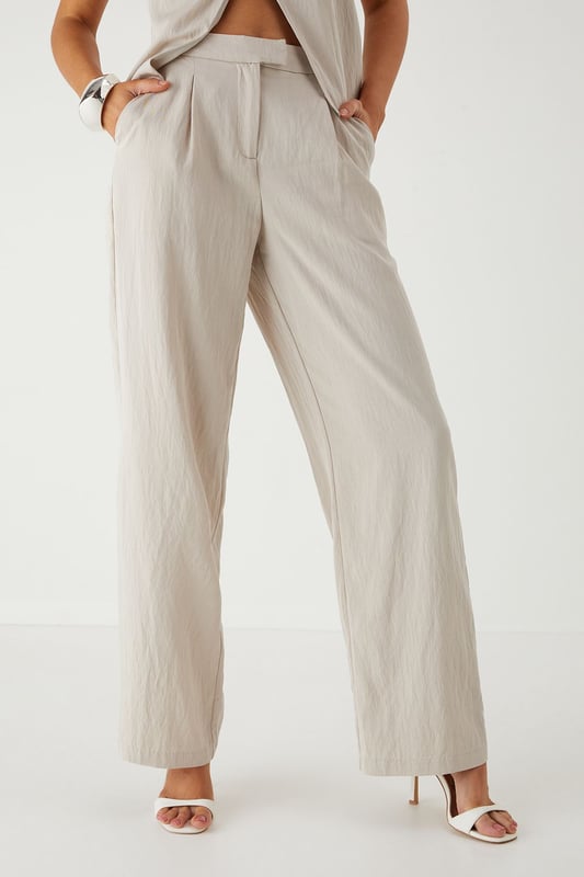 Tailored wide leg design for a dramatic silhouette that commands attention
        Practical side pockets perfect for stashing your essentials on a night out
        High-rise waistband to flatter your figure and provide comfortable all-day wear
        Smooth twill fabric that drapes beautifully with movement
        Versatile design that transitions effortlessly from day to evening events
    
    Make a statement in these MissPap Twill Wide Leg Tailored Trousers, designed to turn heads wherever you go. The dramatic wide leg cut creates a bold silhouette that flows gracefully with every step, whilst the high-rise waistband accentuates your waist for a figure-flattering effect. Style with a cross-halter top as shown for a night on the town, or dress down with a fitted tee and trainers for daytime chic. These trousers work brilliantly for family gatherings when paired with a soft blouse and flat sandals, or amp up the drama for evening drinks with strappy heels and statement jewellery. The side pockets add practical functionality to this fashion-forward piece, making these trousers the perfect addition to your wardrobe for those who want to showcase their confident style whilst maintaining comfort.